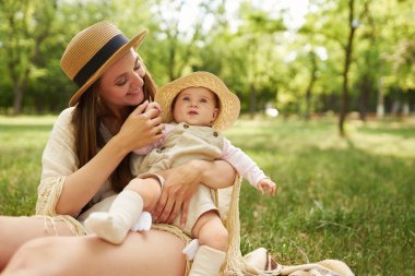 mutlu uyumlu aile açık havada. Anne ile bebeği var fan, gülüyor ve niteliğine yaz oynarken. mutlu bir aile kavramı. yaz gecesi