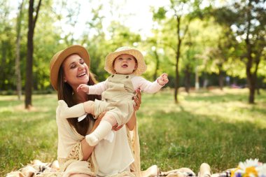 mutlu uyumlu aile açık havada. Anne ile bebeği var fan, gülüyor ve niteliğine yaz oynarken. mutlu bir aile kavramı. yaz gecesi