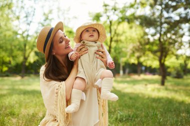 mutlu uyumlu aile açık havada. Anne ile bebeği var fan, gülüyor ve niteliğine yaz oynarken. mutlu bir aile kavramı. yaz gecesi