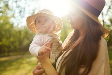 mutlu uyumlu aile açık havada. Anne ile bebeği var fan, gülüyor ve niteliğine yaz oynarken. mutlu bir aile kavramı. yaz gecesi