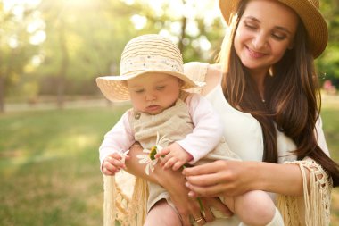mutlu uyumlu aile açık havada. Anne ile bebeği var fan, gülüyor ve niteliğine yaz oynarken. mutlu bir aile kavramı. yaz gecesi