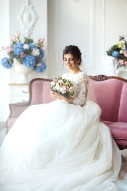 -Beyaz moda düğün saç modeli ile güzel gelin düğün arka plan. Stüdyo çekimi. Buket çiçek ile güzel gelin