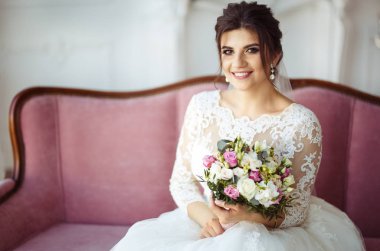 -Beyaz moda düğün saç modeli ile güzel gelin düğün arka plan. Stüdyo çekimi. Buket çiçek ile güzel gelin