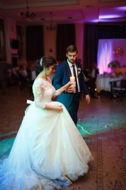 Mutlu gelin ve damat ve güzel ışık ve arka plan üzerinde kişi ile zarif restoranda düğün ilk dansları,