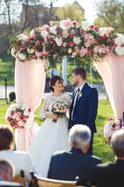 Gelin ve damat düğün töreninde çok güzel görünüyorlar. Düğün çifti dışarıda romantik anlar yaşıyor.