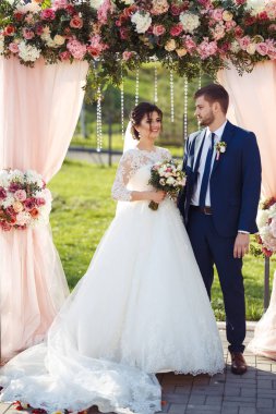 Gelin ve damat düğün töreninde çok güzel görünüyorlar. Düğün çifti dışarıda romantik anlar yaşıyor.