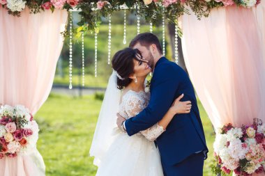 Gelin ve damat düğün töreninde çok güzel görünüyorlar. Düğün çifti dışarıda romantik anlar yaşıyor.