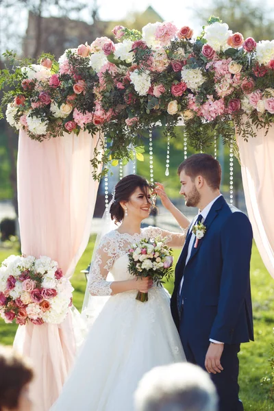 Gelin ve damat düğün töreninde çok güzel görünüyorlar. Düğün çifti dışarıda romantik anlar yaşıyor.