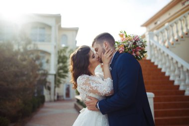 Güzel gelin ve damat hoşlanıyoruz. onların evlilik kutlama mutlu romantik genç bir çift. Aşıkların seksi öpüşme şık çift portre kadar kapatın. Düğün kavramı.