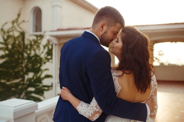 Güzel gelin ve damat hoşlanıyoruz. onların evlilik kutlama mutlu romantik genç bir çift. Aşıkların seksi öpüşme şık çift portre kadar kapatın. Düğün kavramı. günbatımı ışığı