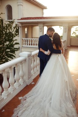 Güzel gelin ve damat hoşlanıyoruz. onların evlilik kutlama mutlu romantik genç bir çift. Aşıkların seksi öpüşme şık çift portre kadar kapatın. Düğün kavramı. günbatımı ışığı