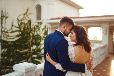 Güzel gelin ve damat hoşlanıyoruz. onların evlilik kutlama mutlu romantik genç bir çift. Aşıkların seksi öpüşme şık çift portre kadar kapatın. Düğün kavramı. günbatımı ışığı