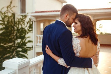 Güzel gelin ve damat hoşlanıyoruz. onların evlilik kutlama mutlu romantik genç bir çift. Aşıkların seksi öpüşme şık çift portre kadar kapatın. Düğün kavramı. günbatımı ışığı