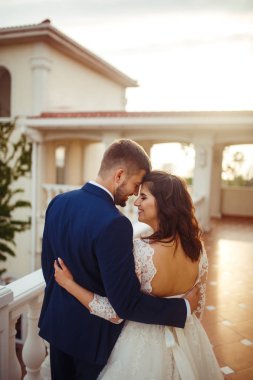 Güzel gelin ve damat hoşlanıyoruz. onların evlilik kutlama mutlu romantik genç bir çift. Aşıkların seksi öpüşme şık çift portre kadar kapatın. Düğün kavramı. günbatımı ışığı