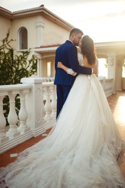 Güzel gelin ve damat hoşlanıyoruz. onların evlilik kutlama mutlu romantik genç bir çift. Aşıkların seksi öpüşme şık çift portre kadar kapatın. Düğün kavramı. günbatımı ışığı