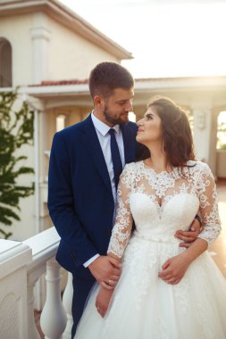 Güzel gelin ve damat hoşlanıyoruz. onların evlilik kutlama mutlu romantik genç bir çift. Aşıkların seksi öpüşme şık çift portre kadar kapatın. Düğün kavramı. günbatımı ışığı