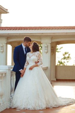 Güzel gelin ve damat hoşlanıyoruz. onların evlilik kutlama mutlu romantik genç bir çift. Aşıkların seksi öpüşme şık çift portre kadar kapatın. Düğün kavramı. günbatımı ışığı