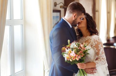 Güzel gelin ve damat otel güzel salonunda hoşlanıyoruz. onların evlilik kutlama mutlu romantik genç bir çift. Aşıkların seksi öpüşme şık çift portre kadar kapatın. Düğün