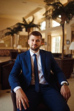 gülümseyen ve otelin salonunda gelin için bekleyen düğün smokin, damat. Zengin düğün gününde damat. Zarif damat kostüm ve Papyon. İlik tutan takım elbiseli damat.