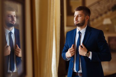 gülümseyen ve otelin salonunda gelin için bekleyen düğün smokin, damat. Zengin düğün gününde damat. Zarif damat kostüm ve Papyon. İlik tutan takım elbiseli damat.