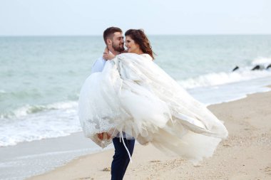 Güzel damat gelin kollarında çember. Yeni evliler hoşlanıyoruz. onların evlilik kutlama mutlu romantik genç bir çift. Aşıkların seksi öpüşme şık çift portre kadar kapatın.