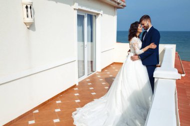 Güzel gelin ve damat okyanus arka plan üzerinde hoşlanıyoruz. onların evlilik kutlama mutlu romantik genç bir çift. Aşıkların seksi şık çift portre kadar kapatın. Düğün kavramı.