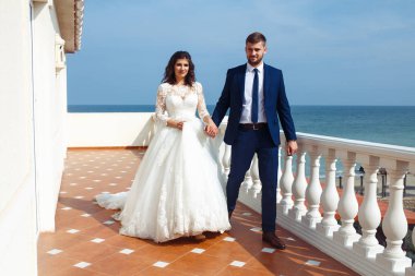 Güzel gelin ve damat okyanus arka plan üzerinde hoşlanıyoruz. onların evlilik kutlama mutlu romantik genç bir çift. Aşıkların seksi şık çift portre kadar kapatın. Düğün kavramı.