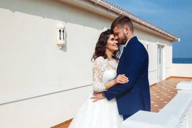 Güzel gelin ve damat okyanus arka plan üzerinde hoşlanıyoruz. onların evlilik kutlama mutlu romantik genç bir çift. Aşıkların seksi şık çift portre kadar kapatın. Düğün kavramı.