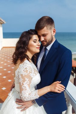 Güzel gelin ve damat okyanus arka plan üzerinde hoşlanıyoruz. onların evlilik kutlama mutlu romantik genç bir çift. Aşıkların seksi şık çift portre kadar kapatın. Düğün kavramı.