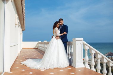 Güzel gelin ve damat okyanus arka plan üzerinde hoşlanıyoruz. onların evlilik kutlama mutlu romantik genç bir çift. Aşıkların seksi şık çift portre kadar kapatın. Düğün kavramı.