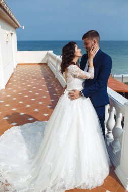 Güzel gelin ve damat okyanus arka plan üzerinde hoşlanıyoruz. onların evlilik kutlama mutlu romantik genç bir çift. Aşıkların seksi şık çift portre kadar kapatın. Düğün kavramı.