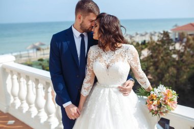 Güzel gelin ve damat okyanus arka plan üzerinde hoşlanıyoruz. onların evlilik kutlama mutlu romantik genç bir çift. Aşıkların seksi şık çift portre kadar kapatın. Düğün kavramı.