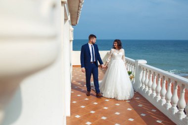 Güzel gelin ve damat okyanus arka plan üzerinde hoşlanıyoruz. onların evlilik kutlama mutlu romantik genç bir çift. Aşıkların seksi şık çift portre kadar kapatın. Düğün kavramı.