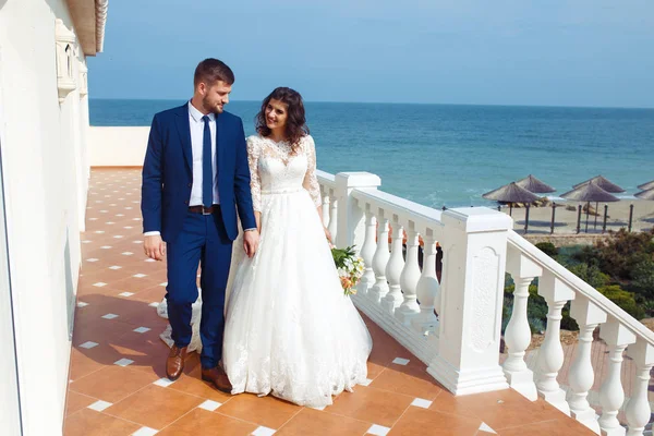 Güzel gelin ve damat okyanus arka plan üzerinde hoşlanıyoruz. onların evlilik kutlama mutlu romantik genç bir çift. Aşıkların seksi şık çift portre kadar kapatın. Düğün kavramı.