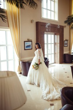 Beyaz bir gelinlikle çok güzel bir gelin şu sedyeyi günbatımı ışığı güzel bir kemer karşı keyif alıyor. İyi bir ruh hali, harika bir atmosfer. Düğün kavramı.