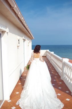 Beyaz bir gelinlikle çok güzel bir gelin şu sedyeyi günbatımı ışığı güzel bir kemer karşı keyif alıyor. İyi bir ruh hali, harika bir atmosfer. Düğün kavramı.