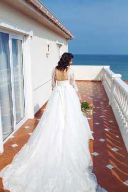 Beyaz bir gelinlikle çok güzel bir gelin şu sedyeyi günbatımı ışığı güzel bir kemer karşı keyif alıyor. İyi bir ruh hali, harika bir atmosfer. Düğün kavramı.