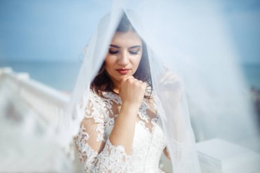 Beyaz bir gelinlikle çok güzel bir gelin şu sedyeyi günbatımı ışığı güzel bir kemer karşı keyif alıyor. İyi bir ruh hali, harika bir atmosfer. Düğün kavramı.