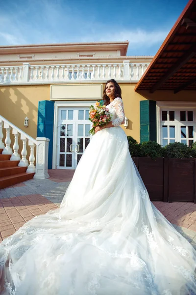 一个穿着白色婚纱的漂亮新娘正享受着在夕阳下的一座美丽拱门的篮板 良好的心情 良好的氛围 婚礼理念 — 图库照片