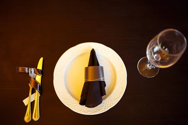 Sparkling glassware stands on long table prepared for wedding dinner.