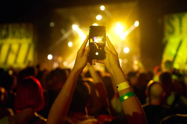 Use advanced mobile recording, fun concerts and beautiful lighting, Candid image of crowd at rock concert, Close up of recording video with smartphone, Enjoy the use of mobile photography