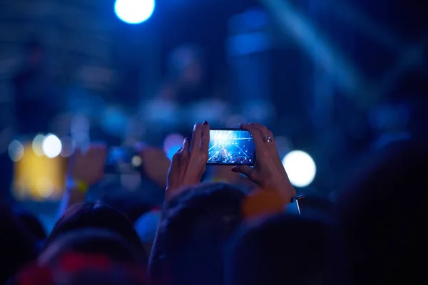 Use advanced mobile recording, fun concerts and beautiful lighting, Candid image of crowd at rock concert, Close up of recording video with smartphone, Enjoy the use of mobile photography