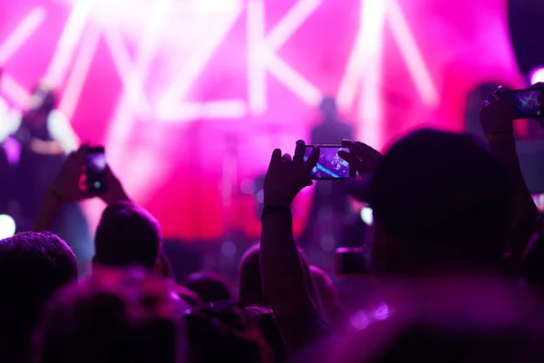 Use advanced mobile recording, fun concerts and beautiful lighting, Candid image of crowd at rock concert, Close up of recording video with smartphone, Enjoy the use of mobile photography