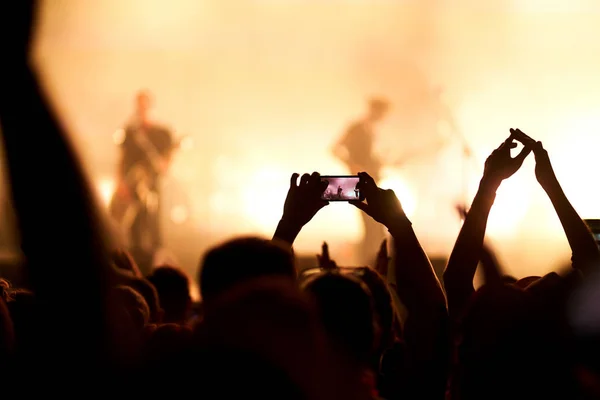 Use advanced mobile recording, fun concerts and beautiful lighting, Candid image of crowd at rock concert, Close up of recording video with smartphone, Enjoy the use of mobile photography