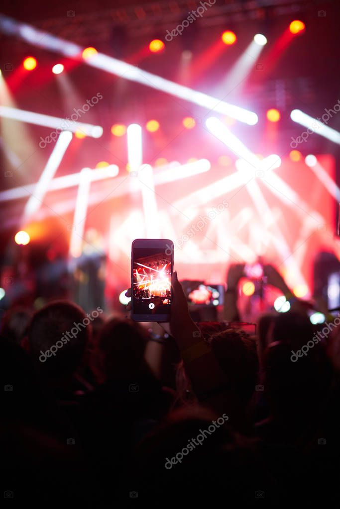 Use advanced mobile recording, fun concerts and beautiful lighting, Candid image of crowd at rock concert, Close up of recording video with smartphone, Enjoy the use of mobile photography