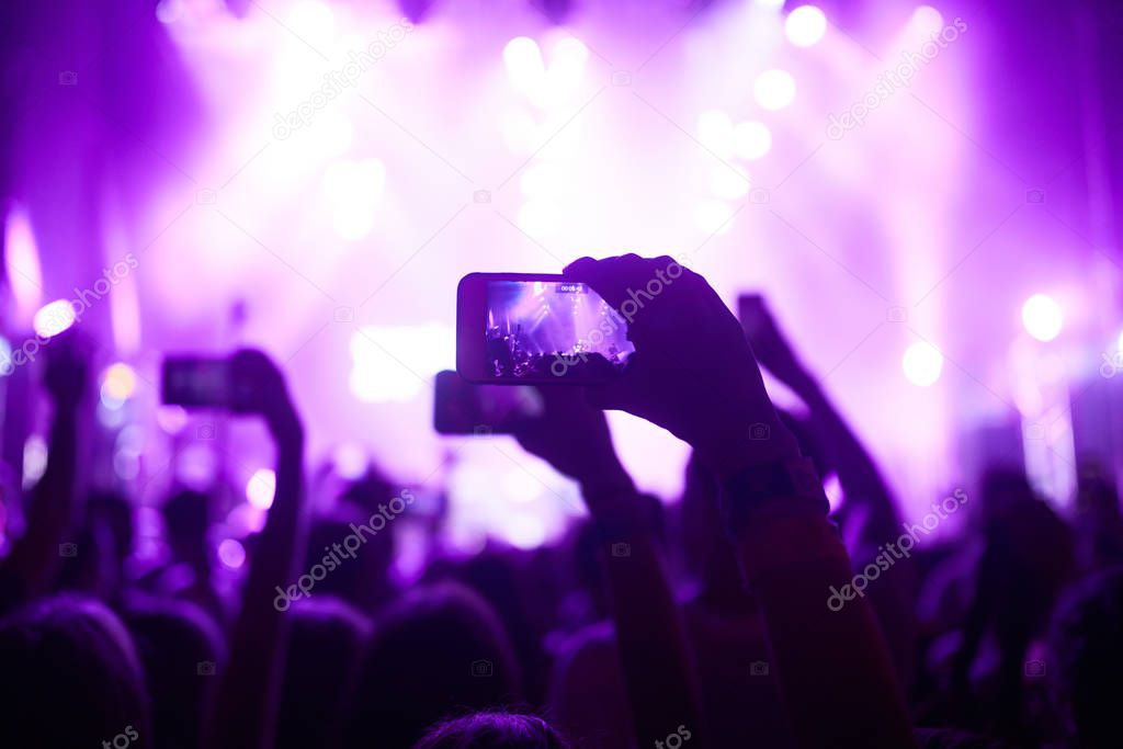 Use advanced mobile recording, fun concerts and beautiful lighting, Candid image of crowd at rock concert, Close up of recording video with smartphone, Enjoy the use of mobile photography