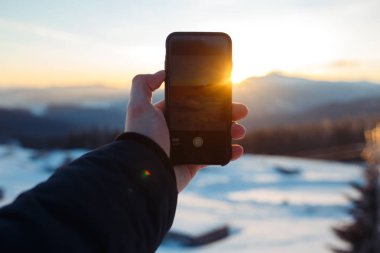 Adam dağlarda güzel gündoğumu bir telefon alır. dağların güzel manzara. Seyahat, özgürlük, doğanın güzelliği kavramı. güzel bir gün, güneşli hava, mavi gökyüzü.