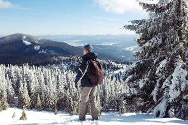Dağlarda trekking sırt çantası olan adam. Soğuk hava, kar tepelerde. Hiking kış. Kış geliyor, yılın ilk karı yağıyor. seyahat, dinlenme, rahatlama kavramı 