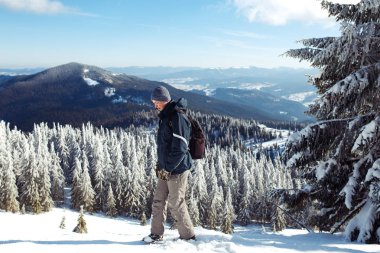 Dağlarda trekking sırt çantası olan adam. Soğuk hava, kar tepelerde. Hiking kış. Kış geliyor, yılın ilk karı yağıyor. seyahat, dinlenme, rahatlama kavramı 