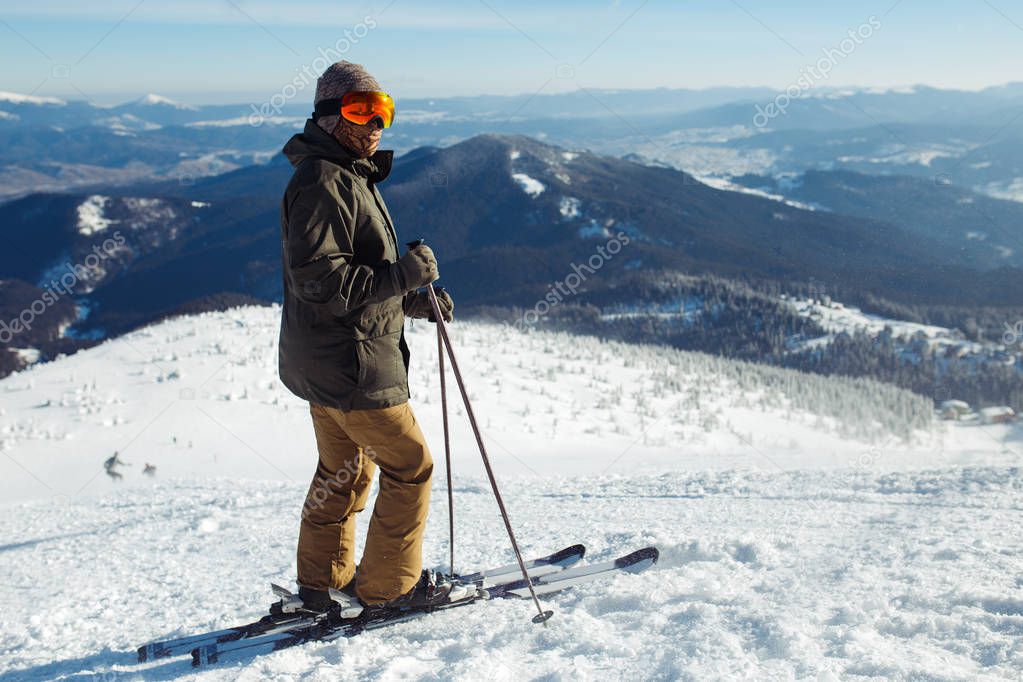 Nice man skiing in the mountains. Good skiing in the snowy mountains,  Winter is coming, first snowfall. Ski resort season is open. Ski equipment, trail.